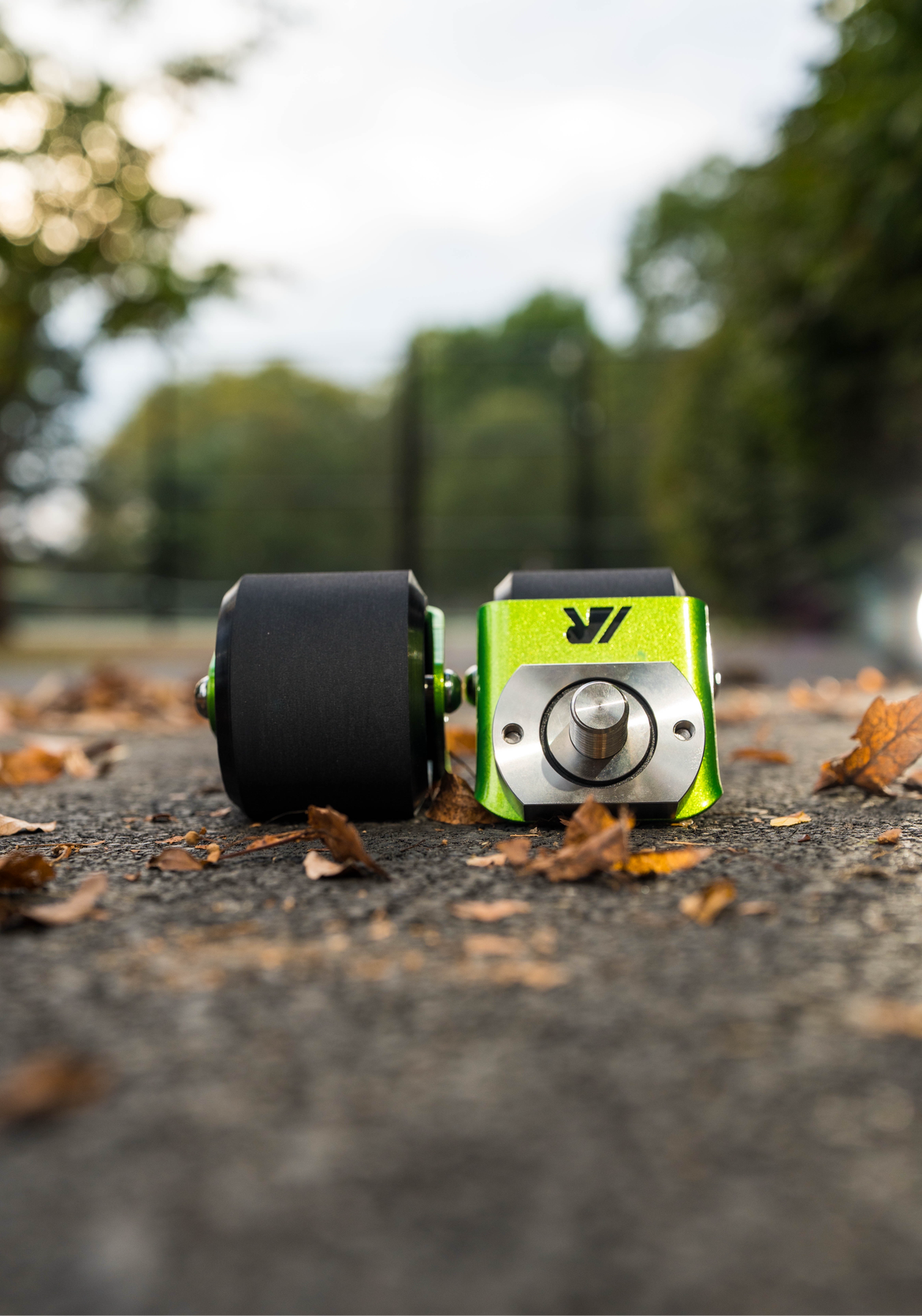 A pair of green crazy cart wide casters on a path. 