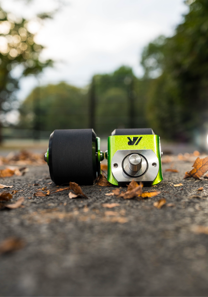 A pair of green crazy cart wide casters on a path. 